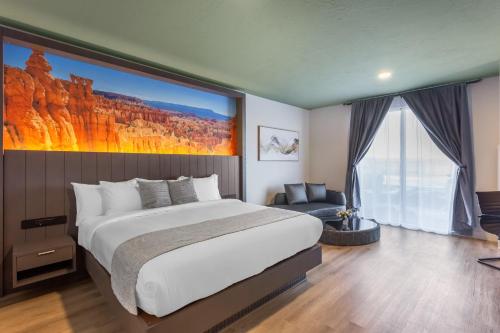 ein Schlafzimmer mit einem Bett und einem großen Gemälde an der Wand in der Unterkunft The Valor, an Ascend Collection Hotel in Parowan