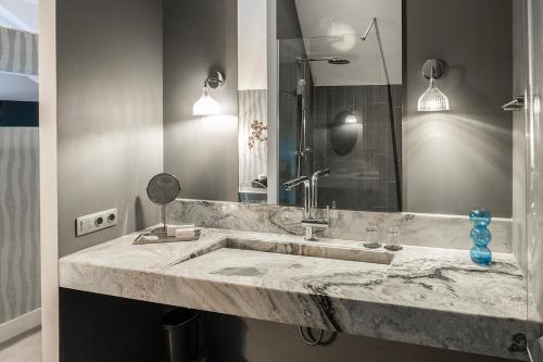 a bathroom with a marble sink and a mirror at Weaving Mill Hotel Suites And Shared Kitchen in Oss