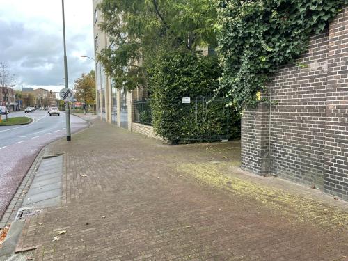 an empty sidewalk next to a brick building at Weaving Mill Hotel Suites And Shared Kitchen in Oss
