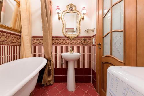 a bathroom with a tub and a sink and a mirror at Duke Apartments in Vilnius