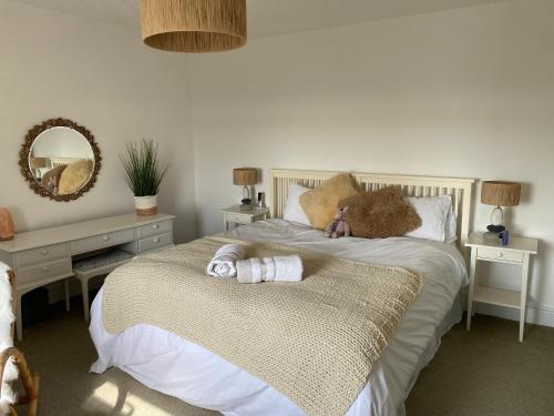a bedroom with a bed with a teddy bear laying on it at Homely Pembrokeshire Farmhouse in Tenby