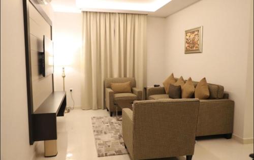 a living room with a couch and chairs and a television at شقق قولد ان للشقق المخدومة in Riyadh