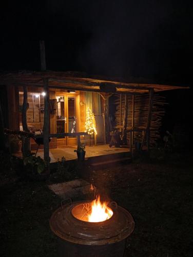 a fire pit in front of a cabin at night at La maison du pêcheur in Saint-Justin