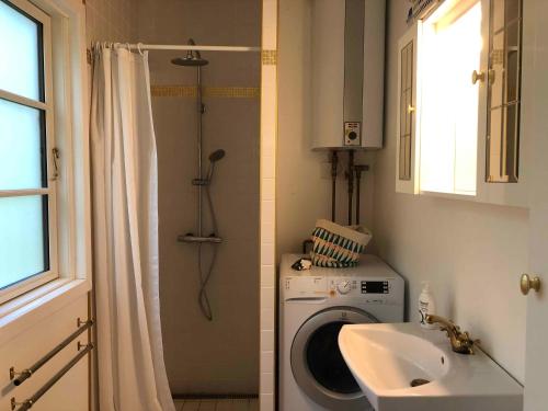 een badkamer met een wasmachine en een wastafel bij Unique, Artistic House With Fjord View in Holbæk