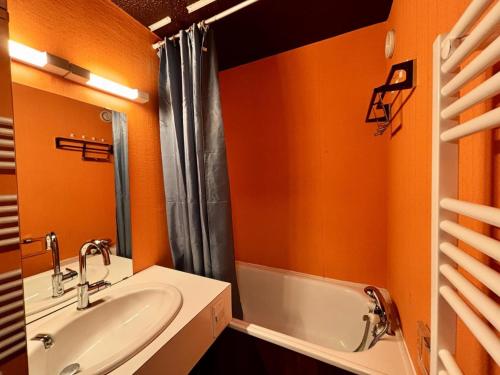 La salle de bains orange est pourvue d'un lavabo et d'une baignoire. dans l'établissement Résidence Fibieres - T2 PIED DES PISTES, FIBIERES, VARS MAE-2431, à Vars
