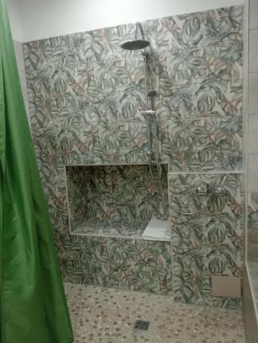 y baño con ducha y pared. en A casa di Aurora -Bed and breakfast, en Caprie