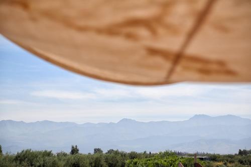 a view of mountains from under an umbrella at La Ferme Berbere Adult only in El Harkat