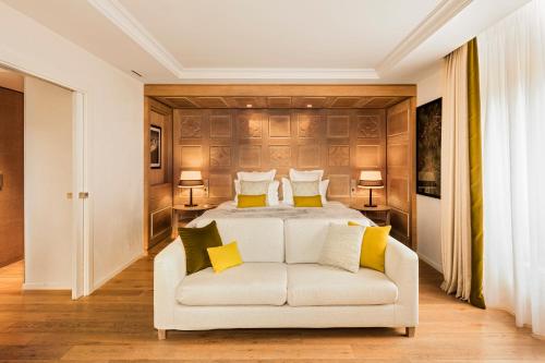 a bedroom with a white bed and a white couch at Hôtel Mont-Blanc Chamonix in Chamonix-Mont-Blanc
