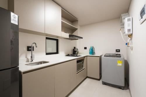 a white kitchen with a sink and a refrigerator at Torre Osadía in La Virginia