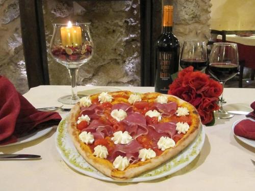una pizza su un tavolo con una candela e bicchieri di vino di Corte dei Monaci a Canicattì