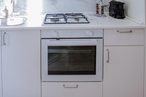 a white kitchen with a stove and a sink at Green Garden in Rome