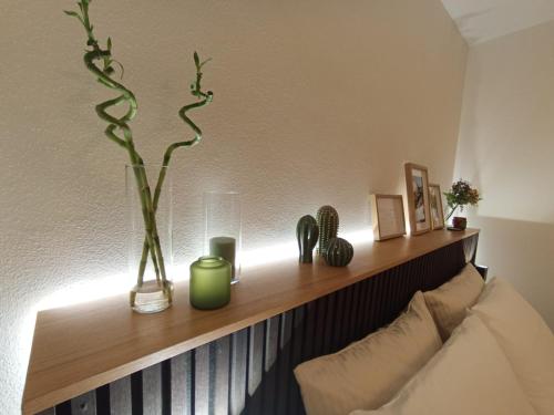 a shelf with vases and plants on a wall at Le Petit Nottolini in Lucca