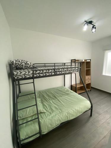 Ce lit superposé se trouve dans un dortoir doté d'un ventilateur de plafond. dans l'établissement Appartement Cosy entre Paris et Disney, à Villiers-sur-Marne