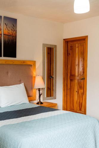a bedroom with a bed and a wooden door at Loft precioso con cocineta parking SmartTV in San Cristóbal de Las Casas