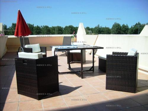 un patio avec une table et des chaises sur un toit dans l'établissement Résidence Héliopolis Bâtiment K - Studio 2 pers. CAP D'AGDE MAE-4534, au Cap d'Agde