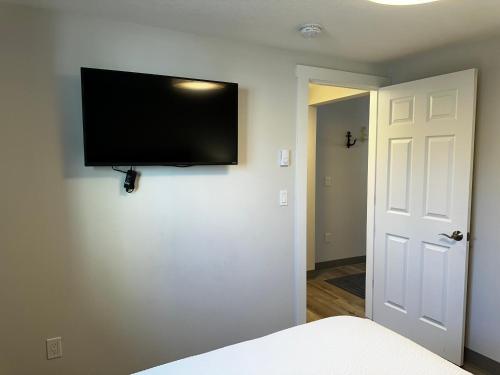a bedroom with a flat screen tv on a wall at West Beach Suites in Lincoln City