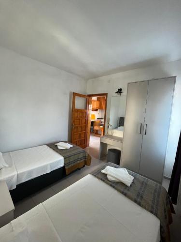 a hotel room with two beds and a bathroom at Ege Apartments in Yalıkavak