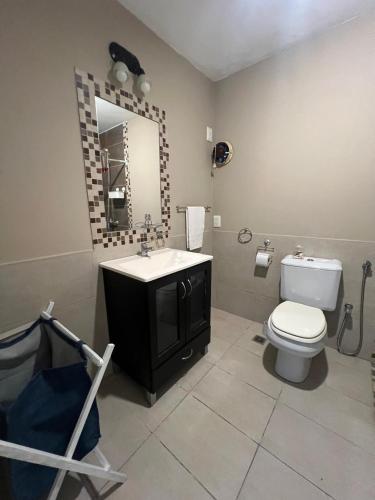 a bathroom with a toilet and a sink and a mirror at Beach House in Santa Teresita