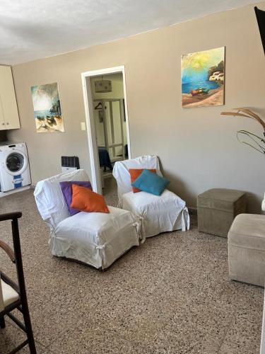 a living room with two chairs and a mirror at Beach House in Santa Teresita