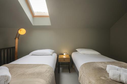 two twin beds in a room with a window at Casa Beira Mar in Aveiro