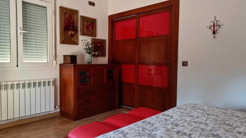 a bedroom with a dresser and a red cabinet at Vivienda Rural Paraje El Sotillo in Carchel