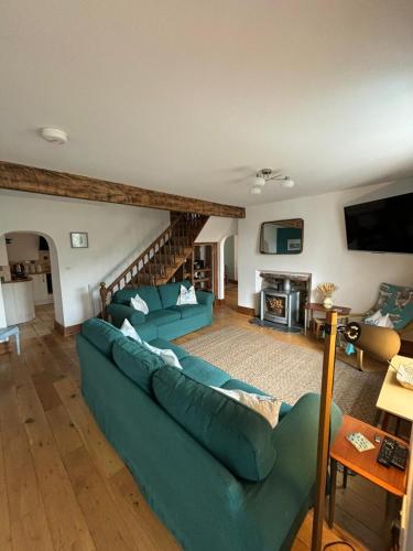 a living room with a blue couch and a fireplace at Mellow Cottage just a short walk to the beach in Perranporth