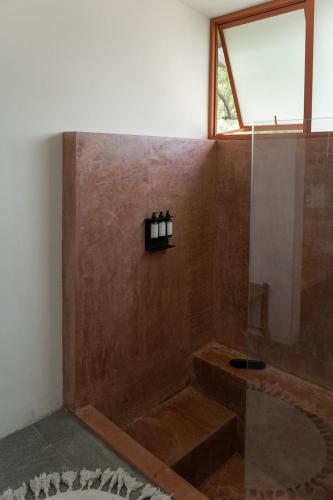 a bathroom with a shower with a sink and a window at Casa Chavela in Tepoztlán