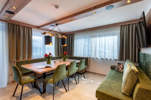 a dining room with a table and chairs and a couch at Anja's Schönblick - Bed & Breakfast in Gerlos