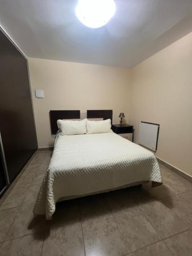 ein Schlafzimmer mit einem großen weißen Bett in einem Zimmer in der Unterkunft El Encanto Jujuy 1 in San Salvador de Jujuy