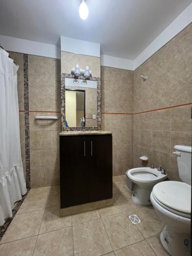 ein Badezimmer mit Toilette, Waschbecken und Spiegel in der Unterkunft El Encanto Jujuy 1 in San Salvador de Jujuy