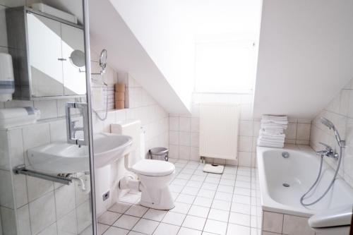 a white bathroom with a toilet and a sink at Maisonette 1 in Bad König