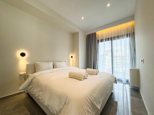 a bedroom with a large white bed with a large window at VILLA 8 By ProLiving Hospitality in Thessaloniki