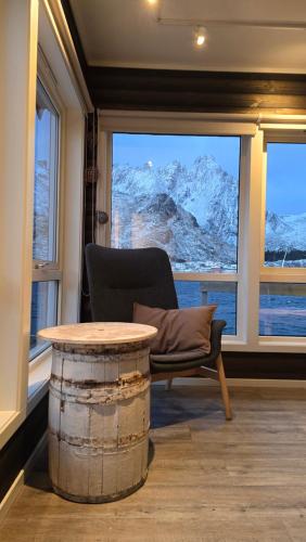 a room with a table and a chair and a window at Hemmingodden Lodge in Ballstad