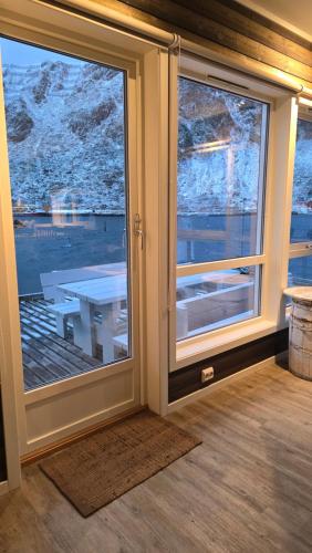 a room with a sliding glass door with a table outside at Hemmingodden Lodge in Ballstad