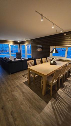 a dining room with a table and a couch at Hemmingodden Lodge in Ballstad