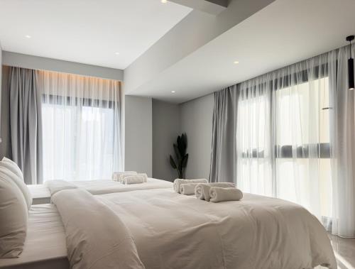 two white beds in a room with large windows at VILLA 8 By ProLiving Hospitality in Thessaloniki