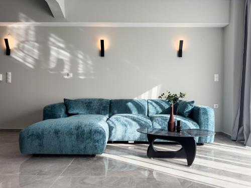 a living room with a blue couch and a table at VILLA 8 By ProLiving Hospitality in Thessaloniki