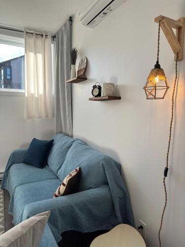 a living room with a blue couch in a room at Bright and Spacious Apartment in Plateau in Gatineau