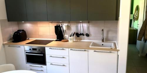 a kitchen with white cabinets and a sink at Two-room apartment with a view Sanctuary in Loreto