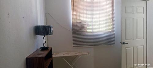 a lamp on a table in a room with a window at ZIHUA TAANAJ in Zihuatanejo