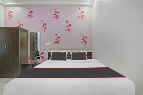 a bedroom with a large bed with red flowers on the wall at Collection O Shivashakti Grand Near Chaudhary Charan Singh International Airport in Banthra Sikandarpur
