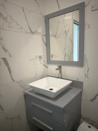 a white bathroom with a sink and a mirror at Beachtown Luxury Villas Apt 104 in Aguacate