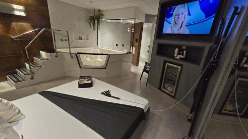 a room with a television and a table with a shoe on it at MOTEL COPACABANA in Ribeirão Preto