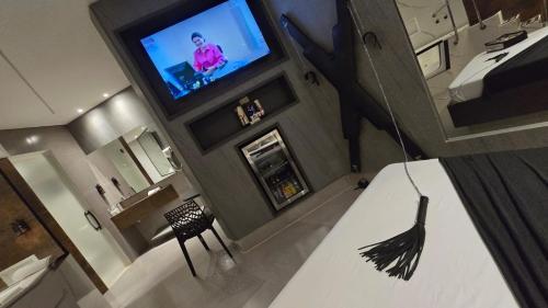 a hotel room with a television and a bedroom at MOTEL COPACABANA in Ribeirão Preto