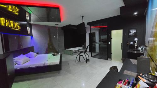 a bedroom with a bed and a desk and a kitchen at MOTEL COPACABANA in Ribeirão Preto