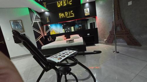 a bedroom with a bed and a chair with the eiffel tower at MOTEL COPACABANA in Ribeirão Preto