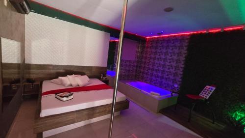 a bedroom with a bed and a purple lighting at MOTEL COPACABANA in Ribeirão Preto