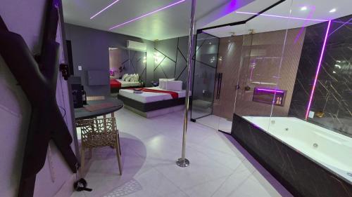 a large bathroom with a tub and a bedroom at MOTEL COPACABANA in Ribeirão Preto