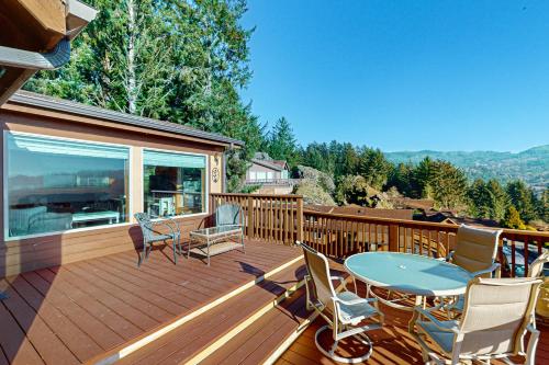 a wooden deck with a table and chairs on it at The Magical Forested Sea Cove in Carpenterville