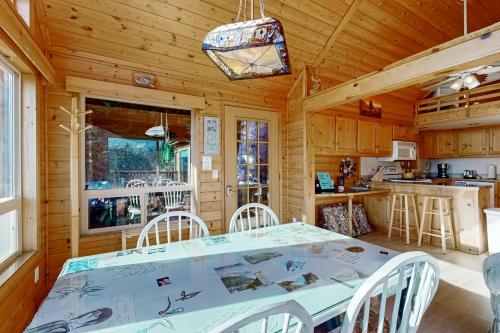 a dining room and kitchen with a table and chairs at The Magical Forested Sea Cove in Carpenterville